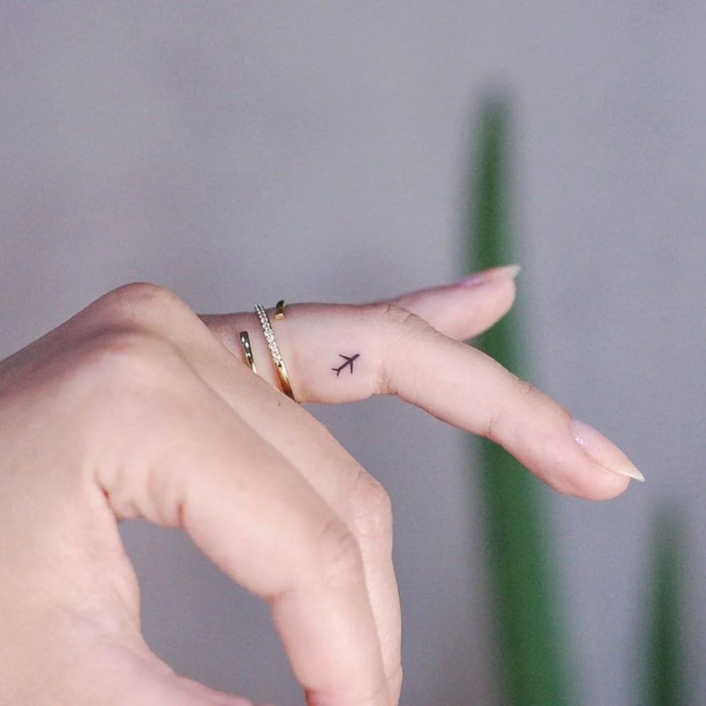 airplane finger tiny tattoo