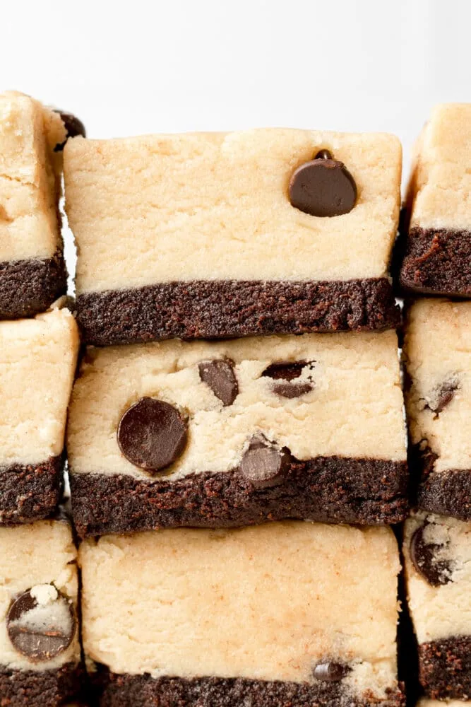 layered dessert bars with a brownie base and thick cookie dough topping, cut into squares