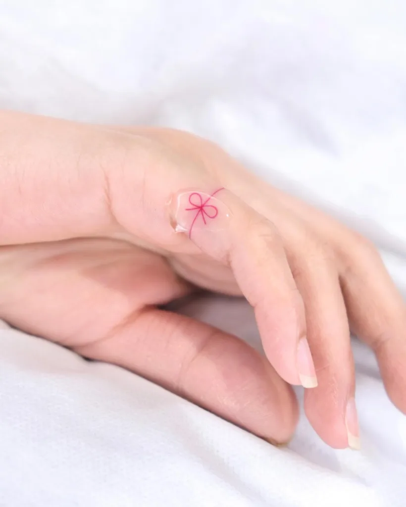 pink bow finger tattoo