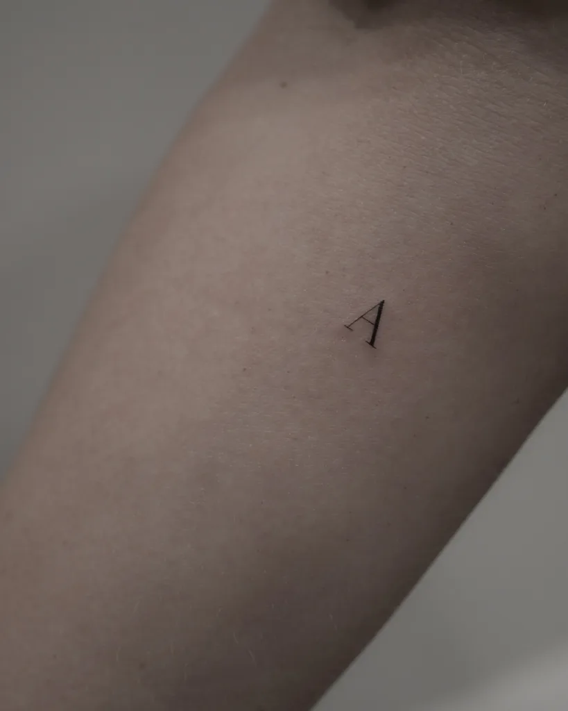 tiny initial tattoo