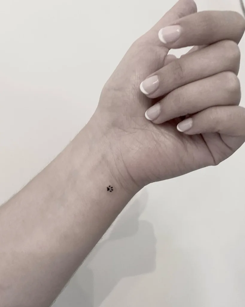 tiny paw print wrist tattoo