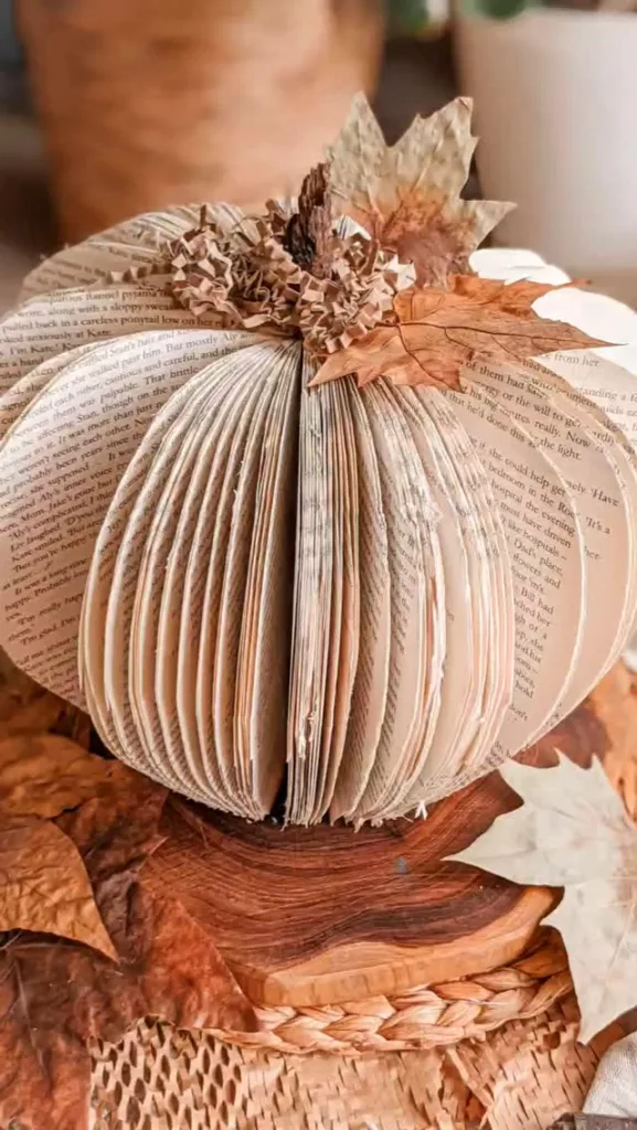 book page pumpkin with dried leaves for an easy fall craft for adults